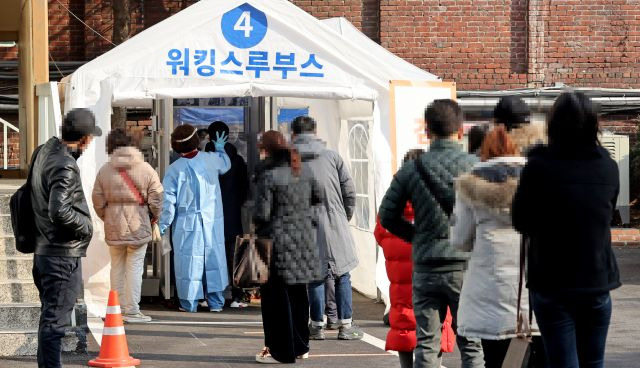 국내 신종 코로나바이러스 감염증(코로나19) 신규 확진자 수가 416명을 기록한 21일 오전 서울 중구 국립중앙의료원에 마련된 코로나19 워킹스루 선별진료소에서 시민들이 검사를 위해 대기하고 있다. 연합뉴스