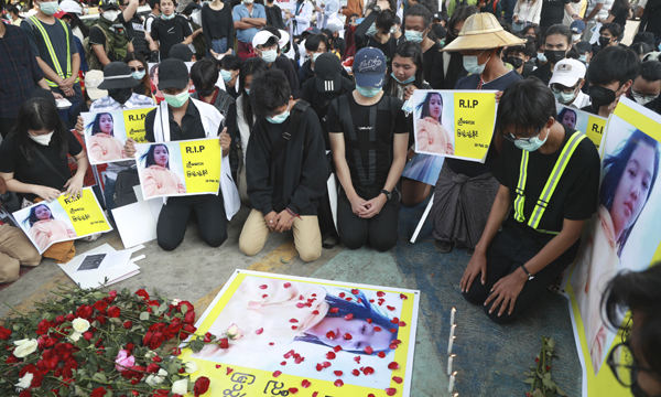 미얀마 군부 쿠데타에 항의하는 시위대가 20일(현지시간) 최대 도시 양곤에서 쿠데타 후 첫 희생자인 미야 테 테 카인의 사진 주변에 무릎을 꿇고 앉아 애도하고 있다. 양곤=AP연합뉴스