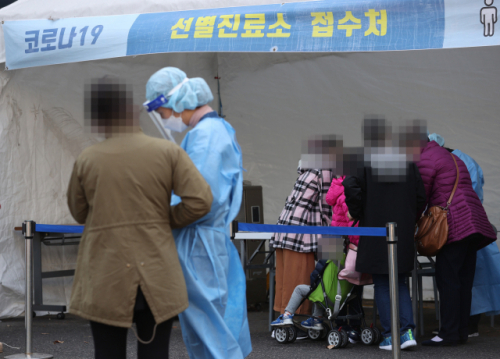 21일 오후 서울 양천구보건소에 마련된 선별진료소에서 한 가족이 검사를 받기 위해 문진표를 작성하고 있다./연합뉴스