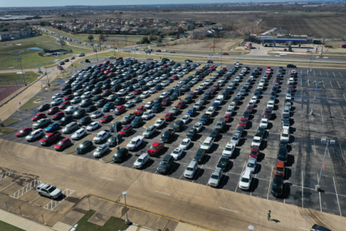 텍사스주 오스틴의 델 발레 고등학교에 설치된 식량 보급소에 가려는 차들이 20일(현지시간) 인근의 주차장에서 길게 줄을 서 있다. /AFP연합뉴스