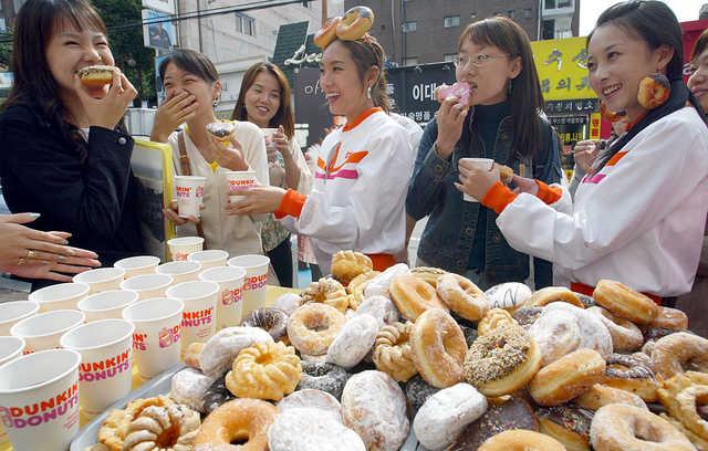 2004년 던킨(당시 던킨도너츠)이 서울 이화여대 정문 매장에서 아침을 거르기 쉬운 직장인과 학생들에게 커피와 도넛을 무료로 나눠 주는 이벤트를 진행하고 있다. 2000년대 초 큰 인기를 끌었던 던킨은 '웰빙' 열풍이 일자 매출 부진을 겪기 시작했다. 한국일보 자료사진