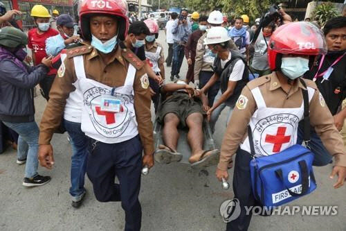 만달레이에서 군경의 총격으로 부상한 시위 참가자가 옮겨지고 있다.   [로이터=연합뉴스]