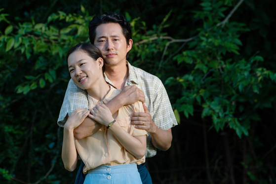 Actors Han Ye-ri, front, and Steven Yeun portray Monica and Jacob, Korean immigrants who arrive in the United States in the 1980s in hopes of finding the American dream in director Lee Isaac Chung's film ″Minari.″ [PAN CINEMA]
