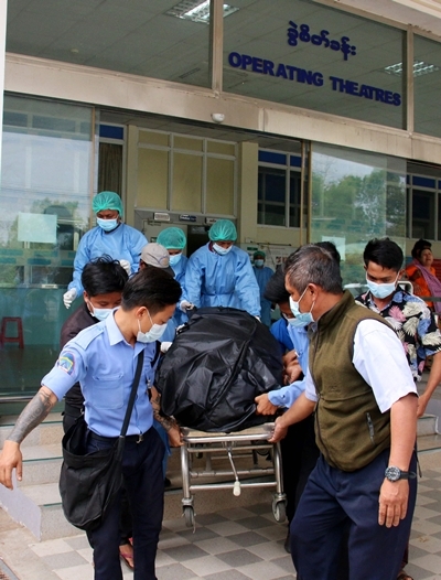 지난 19일 미얀마 수도 네피도의 한 병원에서 의료진이 미얀마 시위 첫 희생자인 먀 뚜웨 뚜웨 카인의 시신을 이송하고 있다. AFP 연합뉴스
