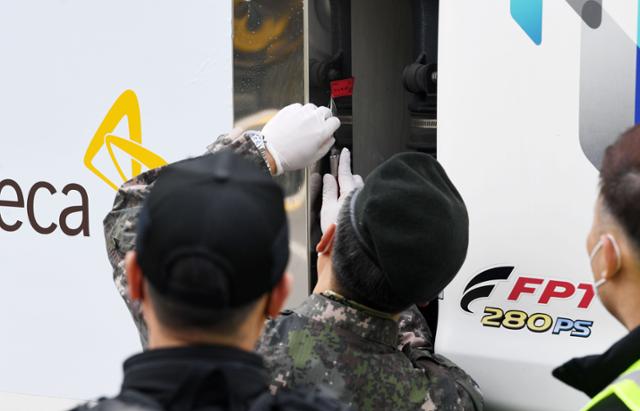 24일 경기 이천 지트리비앤티 물류센터에서 수송 책임자가 백신 수송 차량에 붙은 봉인을 제거하고 있다. 사진공동취재단