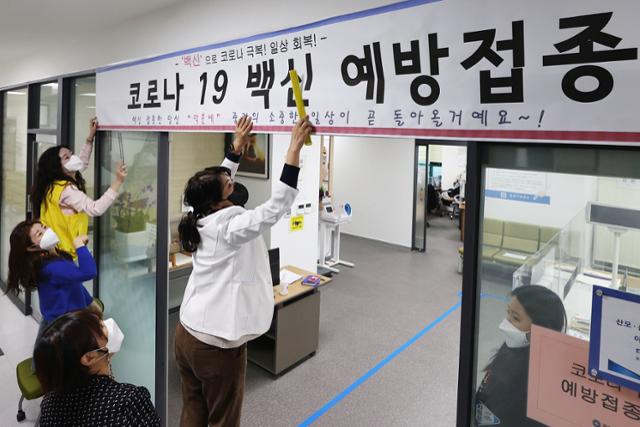 24일 서울 중랑구보건소에서 보건소 관계자들과 구청 직원들이 코로나19 백신접종 안내 현수막을 설치하고 있다. 연합뉴스