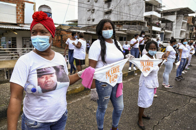 시위 참가자들이 지난 10일(현지시간) 콜롬비아 부에나벤투라에서 무장 범죄조직의 폭력에 반대하기 위해 ‘평화’를 의미하는 하얀색 옷을 입고 나와 인간띠를 만들고 있다. 부에나벤투라|AP연합뉴스