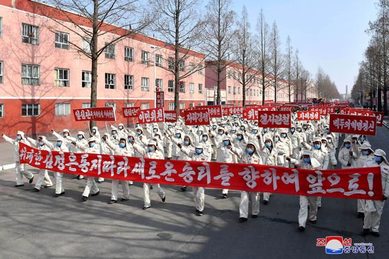 North Korean workers at a steel factory in Hwanghae Province, clad in full anti-epidemic gear, hold a state-sponsored rally on Monday to support the regime's new five-year economic plan, aimed at boosting production levels at such factories. The photo was published by state media. [YONHAP]