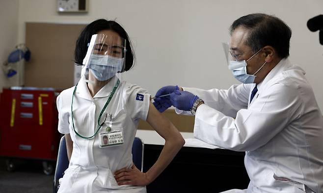 일본에서 의료인을 대상으로 코로나19 백신 접종이 시작된 17일 국립병원기구 도쿄의료센터에서 한 의료인이 백신을 맞고 있다.도쿄=AP연합뉴스