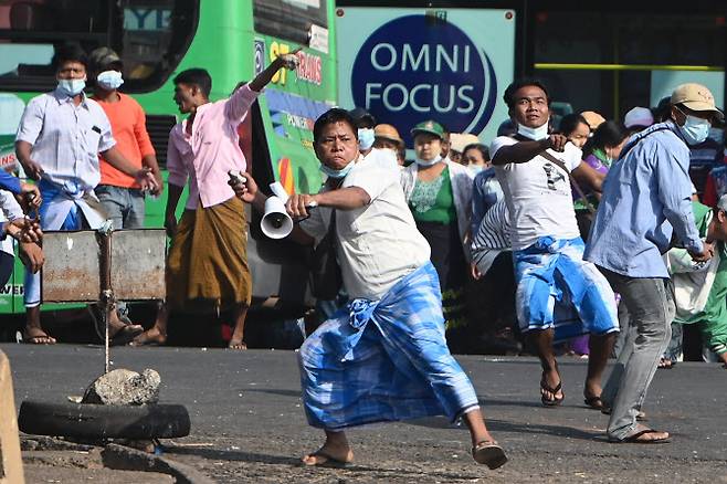 25일 미얀마 양곤에서 군부를 지지하는 시위대가 반쿠데타 시위대를 향해 돌을 던지고 있다(사진=AFP)