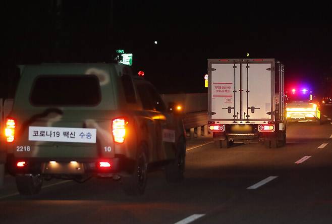 Police and military vehicles escort a truck transporting AstraZeneca vaccines on Feb. 25. (Yonhap News)