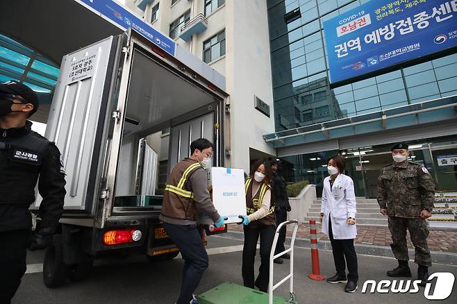 26일 오후 광주 조선대학교병원 의성관(호남권역 예방접종센터) 1층에서 백신 수송요원들이 군사경찰과 군인의 경호 속에서 화이자 백신을 차량에서 내리고 있다. 2021.2.26/뉴스1 © News1 황희규 기자