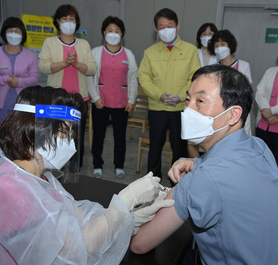 황순구 한솔요양병원장이 26일 오전 대구시 북구 한솔요양병원에서 시내 '코로나19' 첫 백신접종자로 백신을 맞고 있다. 이 모습을 권영진 대구시장 등 관계자들이 지켜보고 있다. 사진=대구시 제공