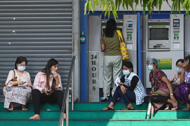 23일 미얀마 양곤 도심에서 시민들이 돈을 뽑기 위해 현금자동입출금기 앞에 줄 서 있다. 양곤=AFP 연합뉴스