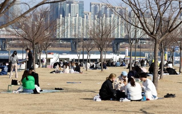 지난 26일 오후 서울 영등포구 여의도한강공원에서 시민들이 잔디밭에 앉아 휴식을 취하고 있다. /연합뉴스