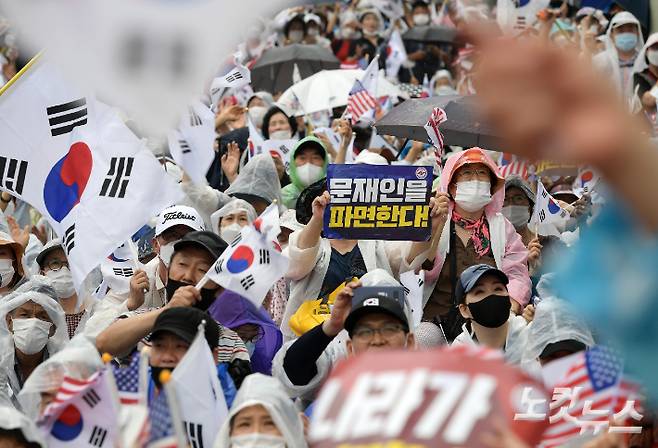 지난해 8월 15일 오후 서울 종로구 동화면세점 앞에서 열린 보수단체의 광복절 집회에서 참서자들이 태극기를 흔들고 있다. 이한형 기자