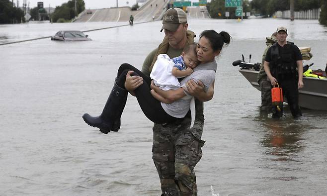 2017년 8월 허리케인 ‘하비’로 물에 잠긴 미국 텍사스주의 한 도로에서 구조대원이 아이를 안은 여성을 대피시키고 있다. 당시 피해복구에 한창이던 텍사스주에는 12년 전 허리케인 ‘카트리나’ 때 도움을 받았던 루이지애나주 뉴올리언스 주민들의 지원금과 성원이 되돌아왔다. 트위터 캡처