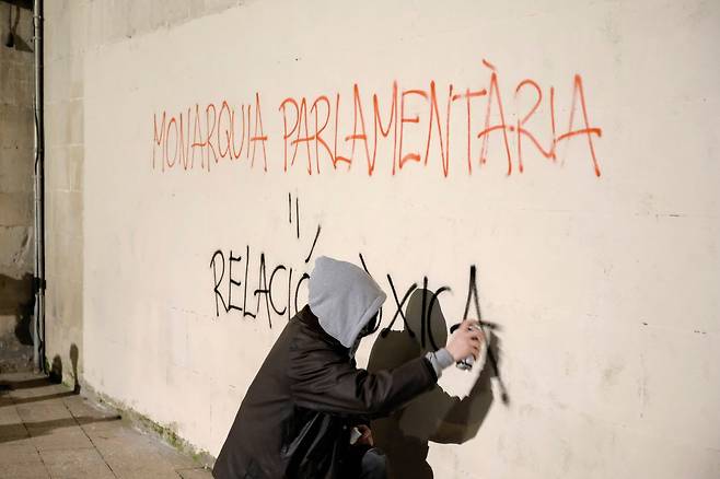 27일 카탈루냐 라이다의 한 반정부 시위대가 벽에 "입헌군주제는 불량한 체제"라는 글씨를 쓰고 있다. EPA=연합뉴스