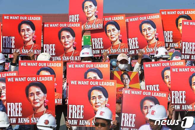 15일(현지시간) 미얀마 네피도에서 군부 쿠데타에 항의하는 시위대가 아웅산 수치의 사진을 들고 석방을 요구하고 있다. © AFP=뉴스1 © News1 우동명 기자