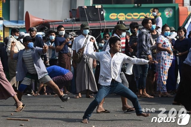 (양곤 AFP=뉴스1) 우동명 기자 = 25일(현지시간) 군사 쿠데타를 규탄하는 대규모 시위가 발생한 미얀마 양곤에서 군부 지지자들이 시위대를 향해 돌을 던지고 있다.   ⓒ AFP=뉴스1