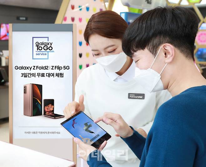 서울 강남구 삼성 디지털프라자 도곡점에서 고객이 갤럭시 팬큐레이터의 안내를 받으며 ‘갤럭시Z폴드2’ 로 ‘개체 지우기(AI 지우개)’ 기능을 체험해보고 있다. (사진= 삼성전자)