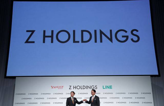 가와베 켄타로(왼쪽) Z홀딩스 CEO와 이데자와 다케시 라인 CEO가 1일 일본 도쿄에서 열린 통합 완료 기자간담회에서 주먹인사하고 있다. 두 CEO는 통합 Z홀딩스 공동 대표를 맡는다. 연합뉴스