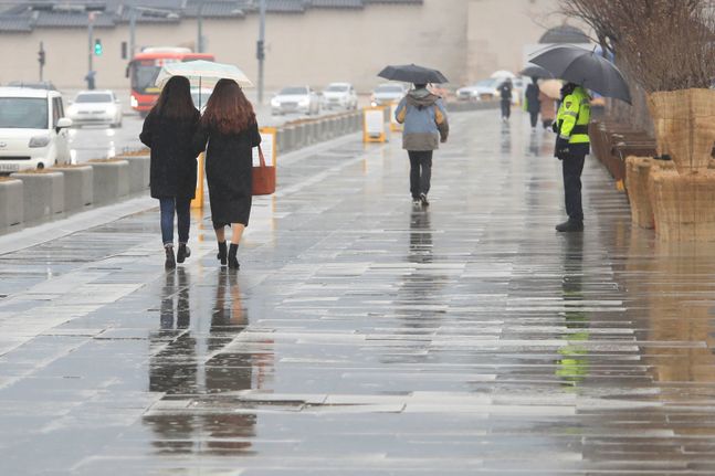 서울 종로구 광화문광장에서 우산을 쓴 시민들이 걷고 있다.ⓒ뉴시스