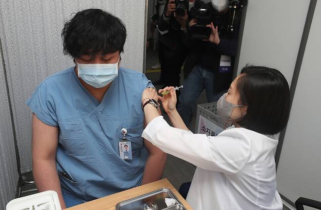지난달 27일 오전 서울 중구 국립중앙의료원 중앙예방접종센터에서 한 의료 종사자가 화이자 백신을 맞고 있다. 사진공동취재단