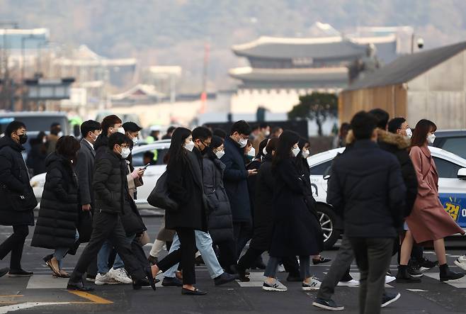 People cross the street near Gwanghwamun area in central Seoul on Wednesday morning to report to work. (Yonhap)