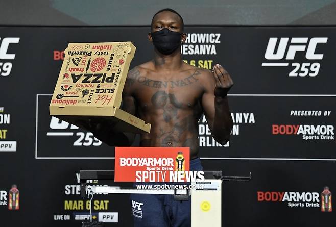 ▲ 이스라엘 아데산야는 체중계 위에서 피자 한 판을 들고 있는 퍼포먼스를 선보였다.