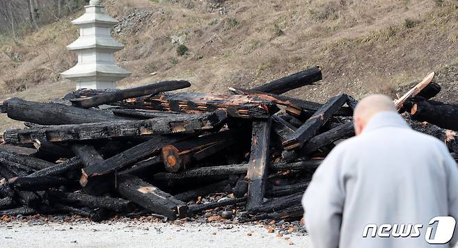 천년의 역사를 간직한 전북 정읍 내장사의 대웅전이 지난 5일 한 승려의 방화로 전소된 가운데 한 스님이 고개를 떨군 채 서 있다. 2021.3.6/뉴스1 © News1 유경석 기자