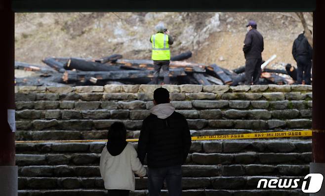 천년의 역사를 간직한 전북 정읍 내장사의 대웅전이 지난 5일 한 승려의 방화로 전소된 가운데 한 부녀가 잿더미로 변한 대웅전을 바라보고 있다. 2021.3.6 /뉴스1 © News1 유경석 기자