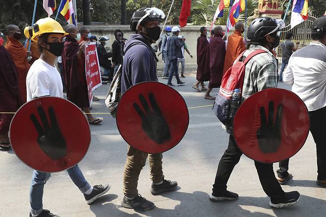 저항의 상징인 '세 손가락'을 그린 방패를 든 만달레이 시민들. AP=연합뉴스