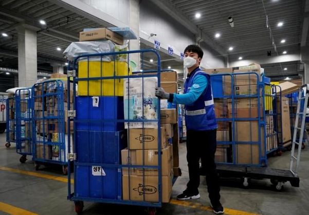 지난해 3월 3일 인천의 쿠팡 물류센터에서 쿠팡친구(배송기사)가 배송 물량을 옮기고 있다. 사진 속 쿠팡친구는 기사 본문과 관련 없음. / 로이터 연합뉴스