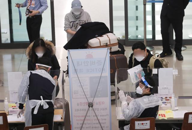 지난달 23일 인천국제공항 제1터미널 입국장에서 해외입국자들이 방역 관계자들로부터 안내를 받고 있다. 영종도=뉴스1