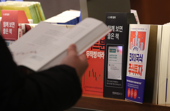 A customer looks at books on stock investment at a book store in central Seoul on Jan. 19. Stock investment interest has risen thanks to the bullish market. [YONHAP]