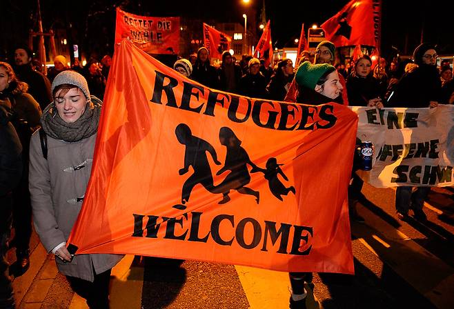 ⓒAP Photo2014년 2월 이민제한법이 통과되자 시민들이 ‘난민 환영’ 플래카드를 들고 항의하고 있다.