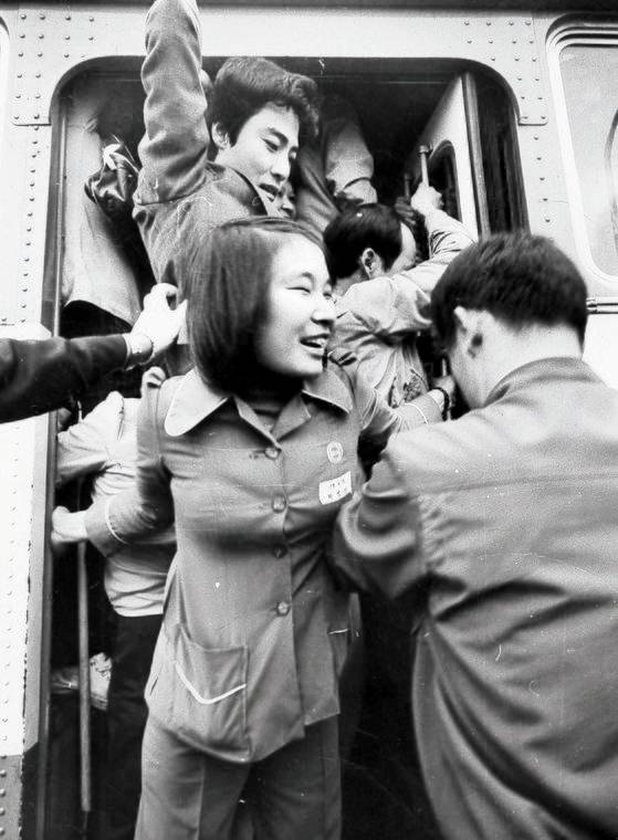 만원 버스에 승객을 몸으로 밀어 넣는 안내양. 버스 안내양은 1961년 도입됐다가 80년대 사라졌다. [중앙포토]