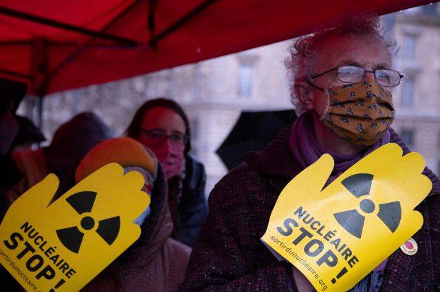 프랑스 파리에서 11일(현지시간) 핵 반대 시민단체가  일본 후쿠시마 원전사고 10주년을 맞아 시위를 연 가운데 시위대가 '핵 중단'이라고 써있는 손팻말을 들어보이고 있다. AFP 연합뉴스