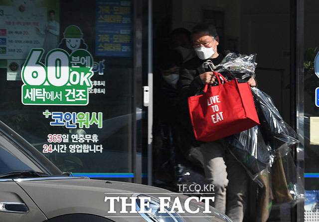 연인 김민희를 위해서라면... 홍상수 감독은 지난해 3월 경기도 하남의 한 상가 세탁소에서 두 팔 가득히 세탁물을 찾아 들고 차량으로 이동하고 있다. /하남=임세준 기자