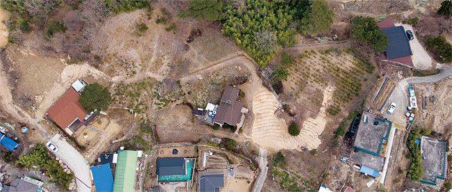 문재인 대통령이 퇴임 이후 머물 경남 양산시 하북면 지산리 평산마을 사저 부지 전경. 가운데 보이는 갈색 지붕 주택이 향후 문 대통령 사저로 새로 지어질 예정이다. 왼쪽에 보이는 붉은색 지붕 주택은 경호동으로 사용된다./한준호 영상미디어 기자