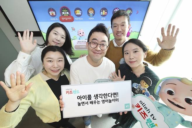 KT 올레TV 키즈랜드 사업을 맡고 있는 키즈서비스팀 강나정 차장(앞줄 맨 왼쪽부터 시계 방향), 백진주 과장, 백원경 과장, 유정민 과장, 이진희 차장이 인기 영어 캐릭터 코코멜론과 레고 등을 들고 활짝 웃고 있다./제공=KT