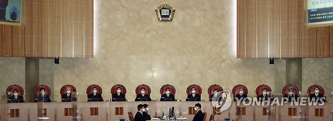 대법원 전원합의체 선고 (서울=연합뉴스) 임헌정 기자 = 김명수 대법원장을 비롯한 대법관들이 18일 오후 서울 서초구 대법원에서 열린 육아휴직급여 부지급 등 처분 취소 전원합의체 선고를 위해 대법정에 입장해 자리에 앉아 있다. 2021.3.18 kane@yna.co.kr