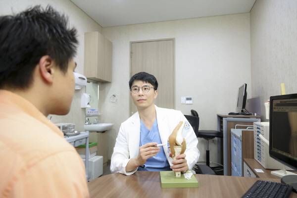 바른세상병원 허재원 원장이 환자에게 관절통에 대해 설명하는 모습.