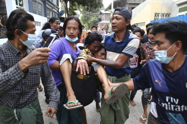 지난 20일 미얀마 만델레이에서 군부독재 항의 시위에 참여한 이들이 군경의 유혈진압에 부상을 입은 한 시민을 옮기고 있다.  /사진=AP연합뉴스