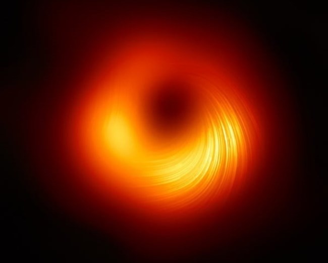 나선형 선이 블랙홀 주변 자기장 편광 방향을 보여준다. 2019년 블랙홀의 첫 이미지가 공개된 후 천문학자들은 블랙홀의 새로운 편광된 모습을 포착했다.사진=EHT Collaboration