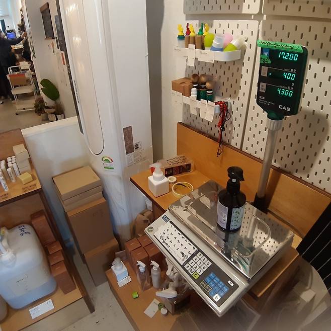 The weight of the body wash refilled by the bottle brought by a customer is measured at Almang Market. (Shin Ji-hye/The Korea Herald)