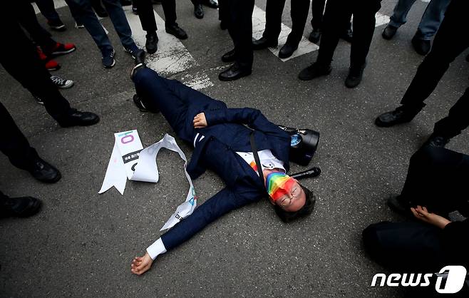 오태양 미래당 서울시장 후보가 2일 오후 서울 양천구 목동깨비시장 앞에서 열린 국민의힘 오세훈 서울시장 후보 선거유세장에서 본인의 선거운동을 하는 가운데 경찰의 제지로 바닥에 쓰러져있다. 2021.4.2/뉴스1 © News1 국회사진취재단