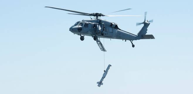 미 해군 MH-60S 헬기가 기뢰 제거장비를 동체 하부에 매단 채 제자리비행을 하고 있다. 레이시온 제공 