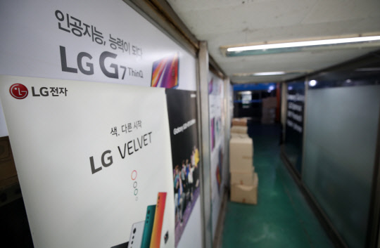 LG전자가 5일 모바일사업을 종료하기로 최종적으로 결정했다. 사진은 이날 서울 용산 휴대폰할인전문상가 내 가게에 붙어 있는 LG전자 스마트폰 광고 포스터. 연합뉴스